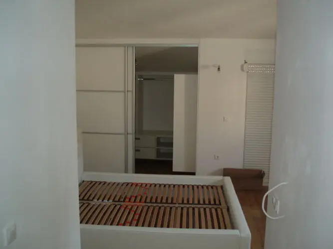 Bijeli bračni krevet s letvičastom podnicom i ormarom s kliznim vratima