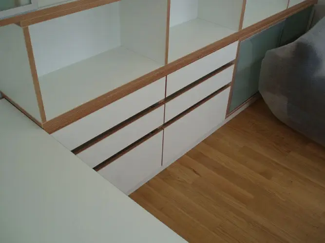 Niski element s bijelim ladicama i policama s rubovima od šperploče