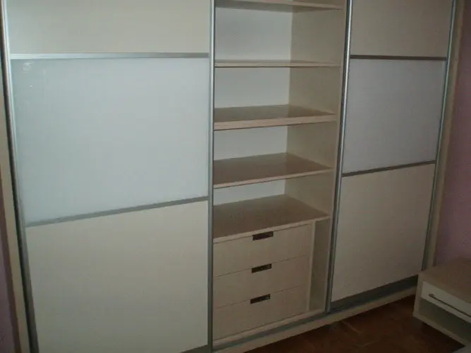 Ormar s kliznim vratima od bijelog stakla i unutarnjim policama s ladicama