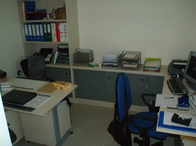 Uredski prostor s niskim sivim ormarićima i policama