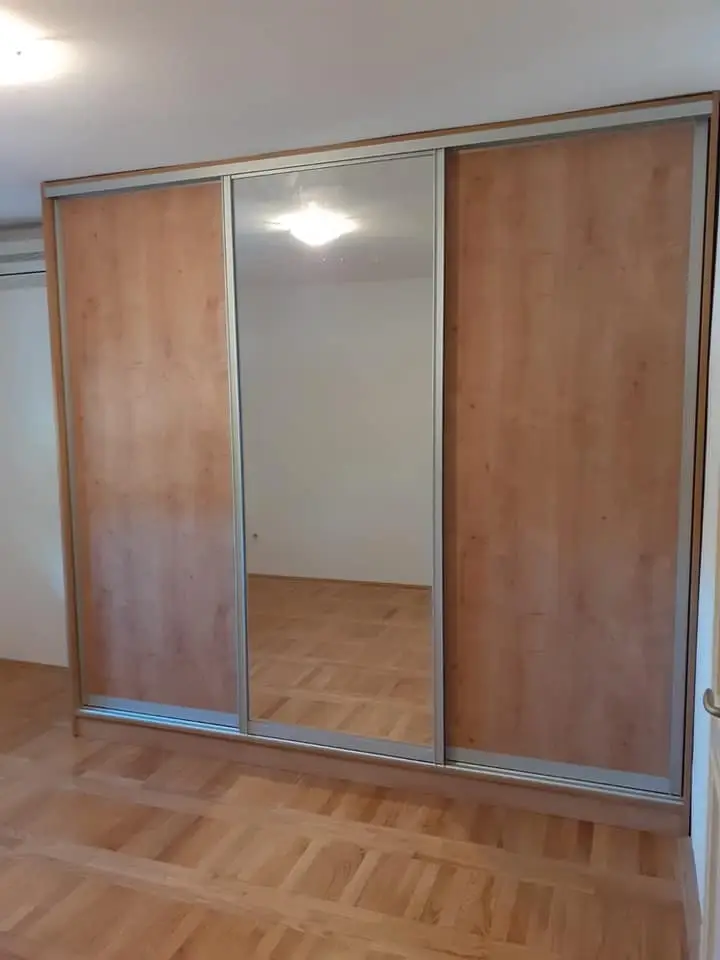 Ormar s troje kliznih vrata, ogledalom u sredini i drvenim dekorom