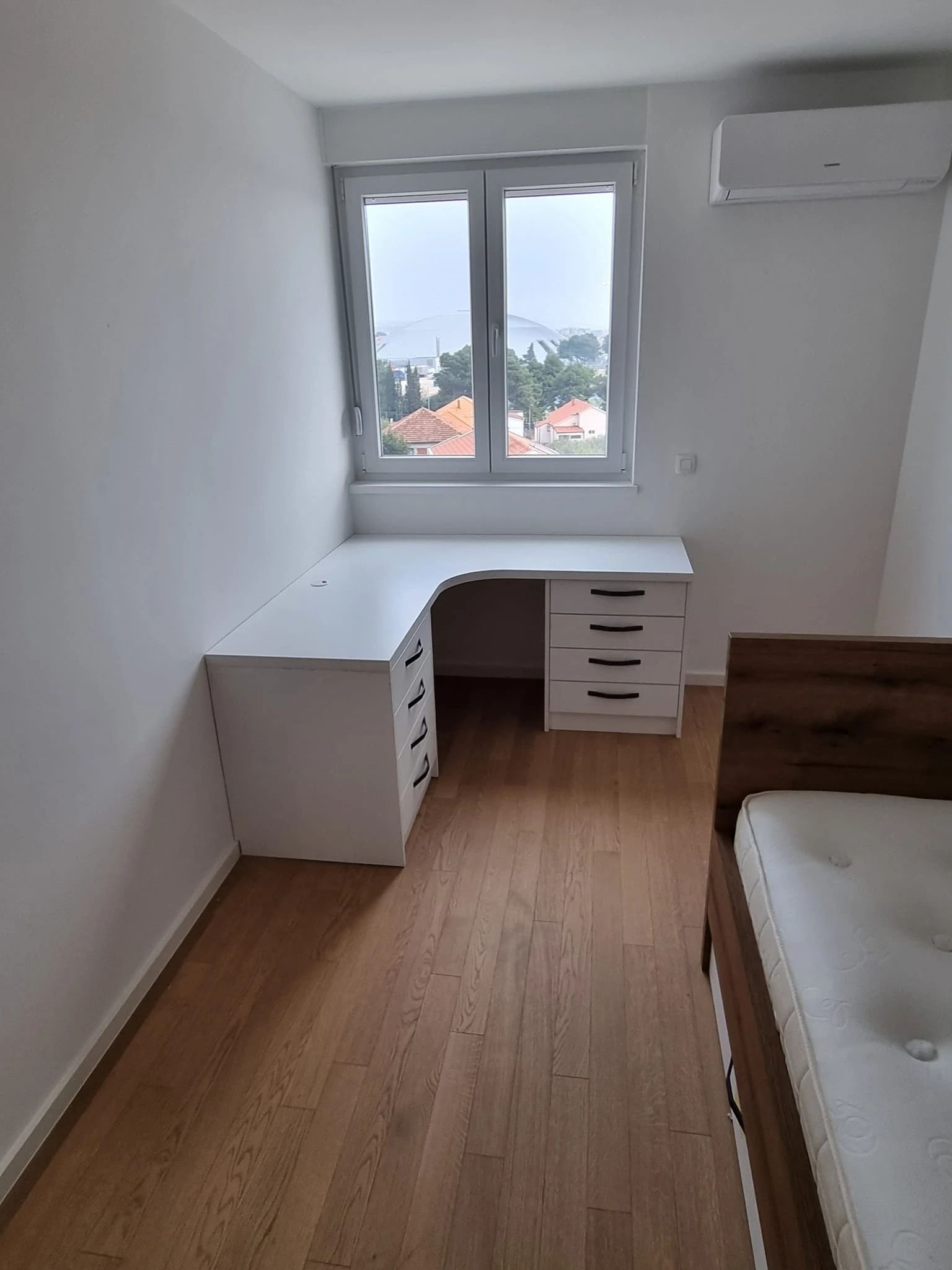 Soba s kutnim radnim stolom i krevetom