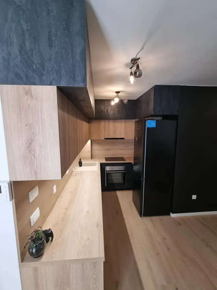 Kuhinja u dekoru hrasta s tamnim gornjim elementima, pogled uz radnu ploču